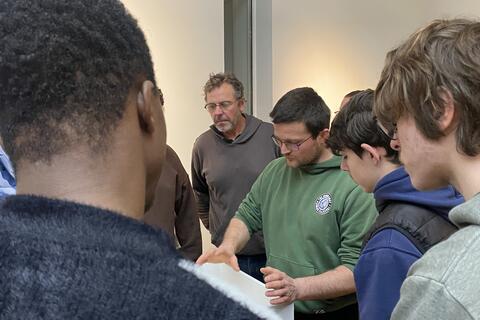 Groupe d'apprentis réunis autour de la maquette de la salle d'exposition 